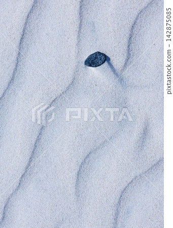 Close-up abstract of perfect wind ripple patterns in white sand dunes forming gentle waves Close-up abstract of perfect wind ripple patterns in white sand dunes forming gentle waves 142875085