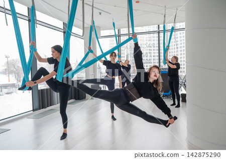 Group yoga class on hammocks. Group yoga class on hammocks. 142875290
