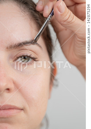 Caucasian woman getting eyebrow tinting procedure.  142875294