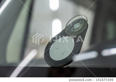 Repairing a chip on a car windshield.  142875309
