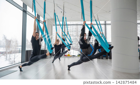 Group yoga class on hammocks. Group yoga class on hammocks. 142875484