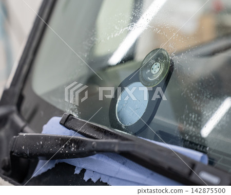 Repairing a chip on a car windshield. Repairing a chip on a car windshield. 142875500