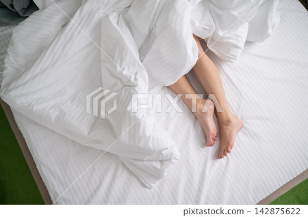 Foot fetish. Bare female feet protruding from under the blanket. Foot fetish. Bare female feet protruding from under the blanket. 142875622