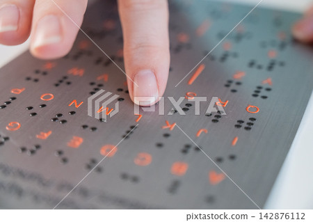 A blind woman learns the English alphabet from a braille sign. A blind woman learns the English alphabet from a braille sign. 142876112