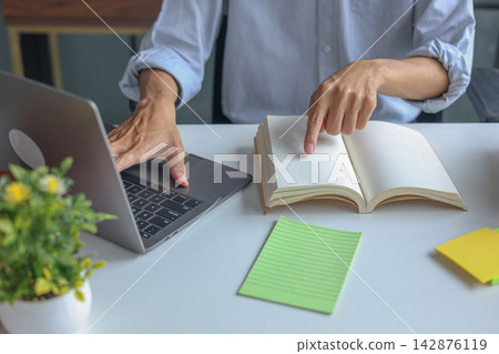 Remote tutor teaching online virtual class via laptop with books on the table. Concept for e-learning or e-teaching. 142876119