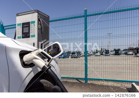 White Electric Car Charging at Modern Station White Electric Car Charging at Modern Station 142876166