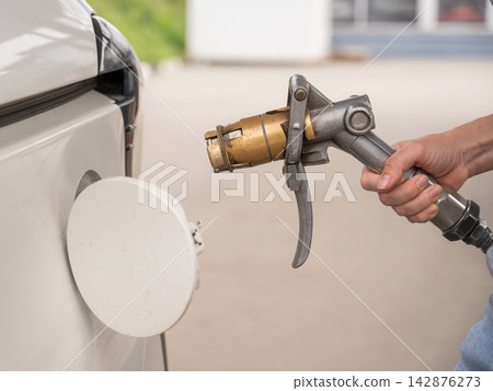 A woman fills a car with gas. Close-up of her hands.  142876273
