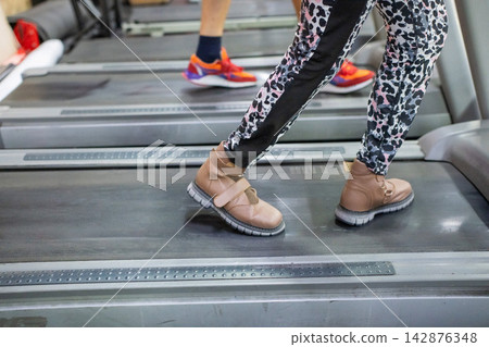 A woman with cerebral palsy walks on a treadmill. A woman with cerebral palsy walks on a treadmill. 142876348