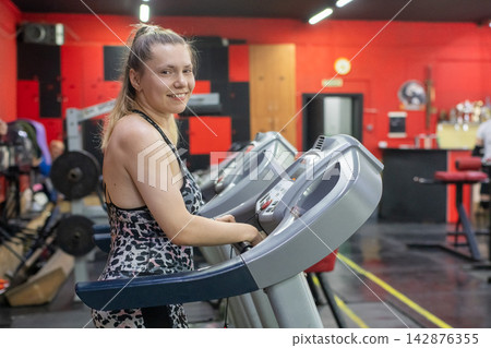A woman with cerebral palsy walks on a treadmill. A woman with cerebral palsy walks on a treadmill. 142876355