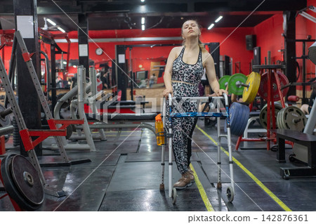 A woman with cerebral palsy works out in the gym. A woman with cerebral palsy works out in the gym. 142876361
