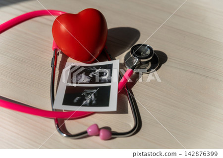 Photo: Ultrasound screening of a child and stethoscope. Image of an embryo. Photo: Ultrasound screening of a child and stethoscope. Image of an embryo. 142876399