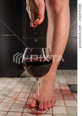 Foot fetish. A woman dips her toes in a glass of red wine. 142876566