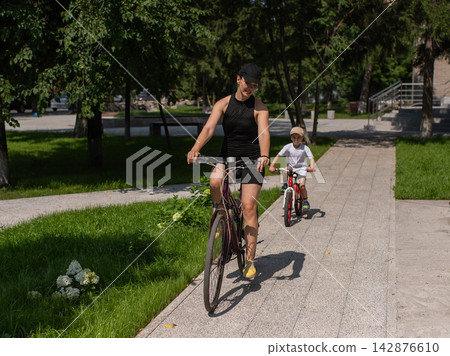 Mother and son riding a bicycle. Mother and son riding a bicycle. 142876610
