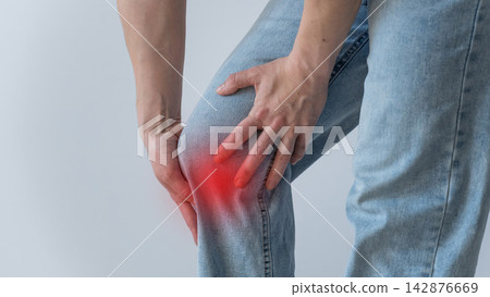 A Caucasian woman suffers from knee pain. The location of the pain is shown as a red spot. A Caucasian woman suffers from knee pain. The location of the pain is shown as a red spot. 142876669