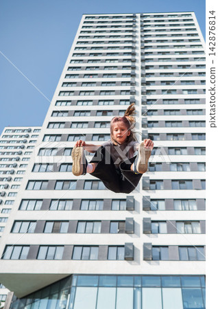 A girl jumps on an outdoor trampoline. A girl jumps on an outdoor trampoline. 142876814