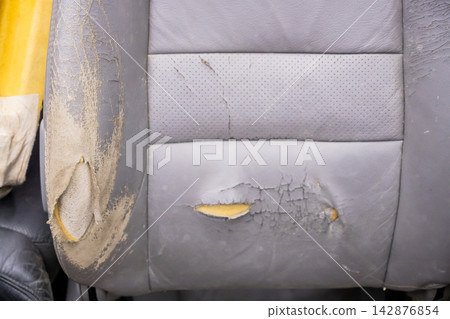 A car seat with worn, torn upholstery. Upholstery replacement. A car seat with worn, torn upholstery. Upholstery replacement. 142876854