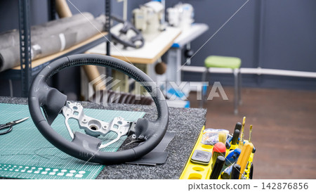 The process of re-upholstering a car steering wheel. The process of re-upholstering a car steering wheel. 142876856