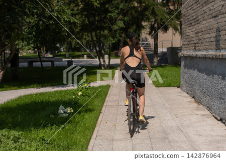 A Caucasian woman riding a bicycle. A Caucasian woman riding a bicycle. 142876964