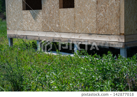 A close-up of concrete piles on a country house under construction. Cottage foundation. A close-up of concrete piles on a country house under construction. Cottage foundation. 142877018
