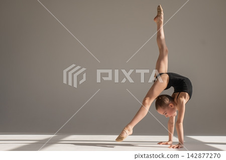 A little girl gymnast does a handstand. Copy space. A little girl gymnast does a handstand. Copy space. 142877270