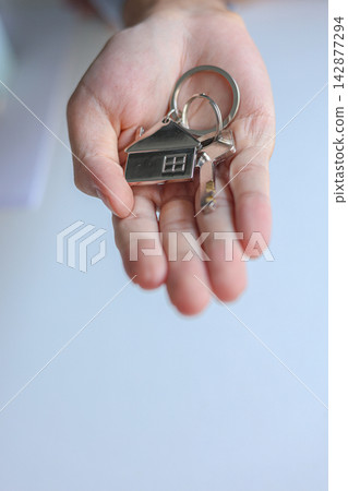 Hand giving house key. Concept for buying, selling, renting or leasing a new home. Hand giving house key. Concept for buying, selling, renting or leasing a new home. 142877294
