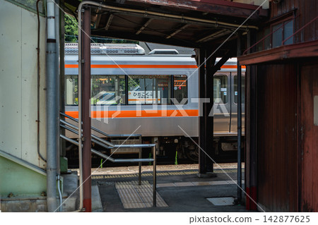 A nostalgic scene of a train stopped at Hida-Kokufu Station in Takayama City, Gifu Prefecture, and its station sign. 142877625