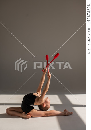Little gymnast posing with clubs on white background. Little gymnast posing with clubs on white background. 142878208