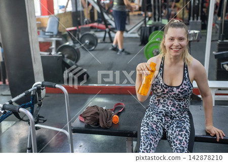 A woman with cerebral palsy works out in the gym. A woman with cerebral palsy works out in the gym. 142878210