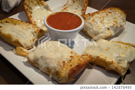 Cheesy Garlic Bread With Marinara Sauce and Sliced Tomatoes on a White Plate Cheesy Garlic Bread With Marinara Sauce and Sliced Tomatoes on a White Plate 142878495