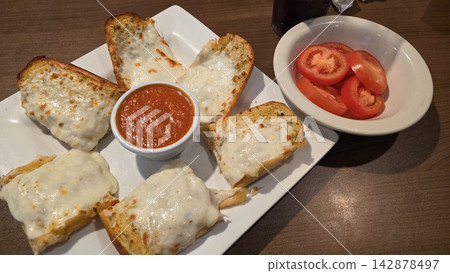 Cheesy Garlic Bread With Marinara Sauce and Sliced Tomatoes on a White Plate Cheesy Garlic Bread With Marinara Sauce and Sliced Tomatoes on a White Plate 142878497