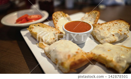 Cheesy Garlic Bread With Marinara Sauce and Sliced Tomatoes on a White Plate 142878501