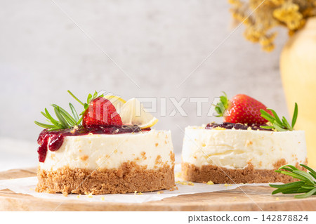 Mini cheesecakes topped with berry jam and fruit Mini cheesecakes topped with berry jam and fruit 142878824