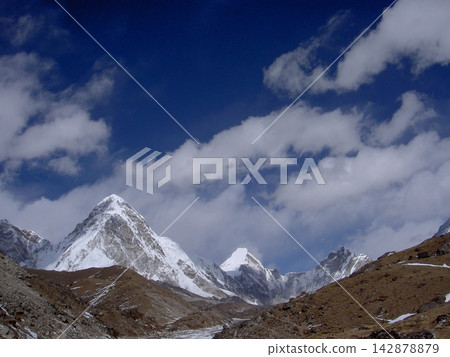 從尼泊爾昆布地區可以欣賞到金字塔形雪山普莫里峰和流動雲朵的美麗景色。 從尼泊爾昆布地區可以欣賞到金字塔形雪山普莫里峰和流動雲朵的美麗景色。 142878879
