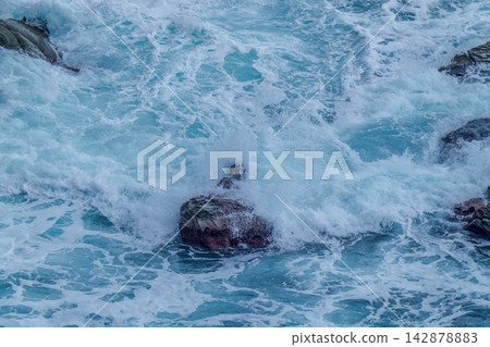 海的紋理,以及洶湧的波濤猛烈地拍打著岩石時濺起的水花。 海的紋理,以及洶湧的波濤猛烈地拍打著岩石時濺起的水花。 142878883