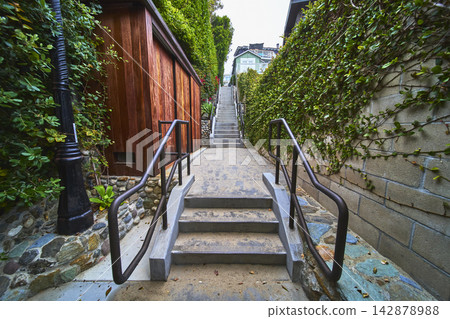 Urban Stairway With Wooden Building Green Vines And Concrete Pathway Urban Stairway With Wooden Building Green Vines And Concrete Pathway 142878988