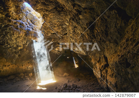 Sunbeam Illuminates Mojave Desert Lava Tube Rock Formations and Dust Particles Sunbeam Illuminates Mojave Desert Lava Tube Rock Formations and Dust Particles 142879007