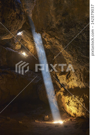 Sunbeam Illuminates Mojave Lava Tube Cave Interior with Dramatic Light and Shadow Sunbeam Illuminates Mojave Lava Tube Cave Interior with Dramatic Light and Shadow 142879037