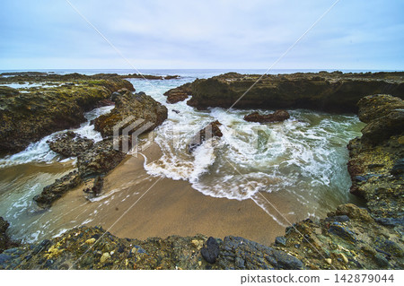 Rocky Shoreline with Ocean Waves and Sandy Beach in Laguna Beach California Rocky Shoreline with Ocean Waves and Sandy Beach in Laguna Beach California 142879044