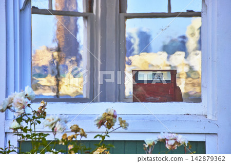 Vintage Red Price Register in Sunlit Window With White Roses and Reflections Vintage Red Price Register in Sunlit Window With White Roses and Reflections 142879362