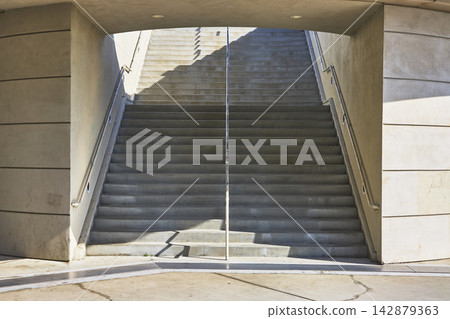 Modern Concrete Staircase with Sunlight and Architectural Symmetry Modern Concrete Staircase with Sunlight and Architectural Symmetry 142879363