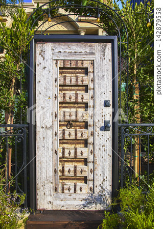 Rustic Wooden Door with Metal Accents in Lush Garden Venice Canal Historic District Rustic Wooden Door with Metal Accents in Lush Garden Venice Canal Historic District 142879558