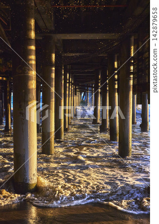 Santa Monica Pier Pillars with Ocean Waves and Golden Hour Reflections Beach California Santa Monica Pier Pillars with Ocean Waves and Golden Hour Reflections Beach California 142879658