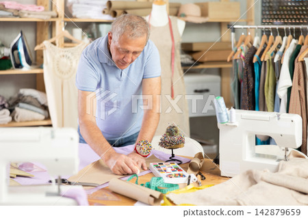 Mature man making markings on paper 142879659
