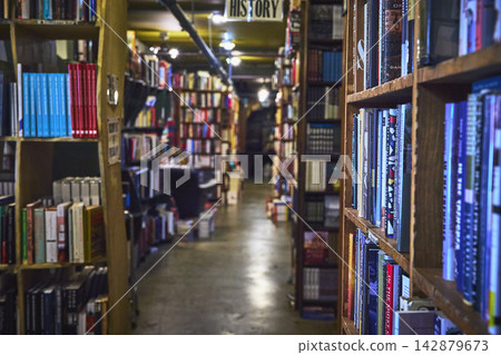 Bookstore Aisle with Tall Wooden Shelves and Colorful Books in Los Angeles Bookstore Aisle with Tall Wooden Shelves and Colorful Books in Los Angeles 142879673