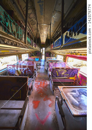 Abandoned Caltrain Passenger Car Interior with Colorful Graffiti and Sunlit Aisle Abandoned Caltrain Passenger Car Interior with Colorful Graffiti and Sunlit Aisle 142879774