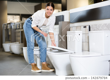 Confident woman picking out new toilet in hardware store Confident woman picking out new toilet in hardware store 142879784