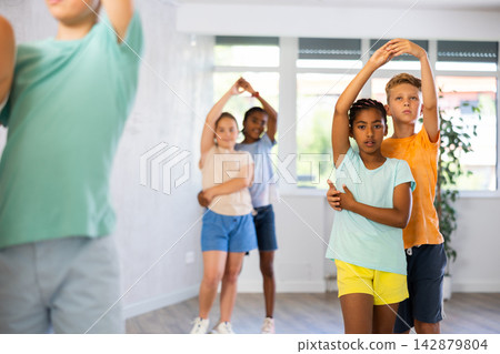 Multinational boys and girls enjoying active dance in studio Multinational boys and girls enjoying active dance in studio 142879804
