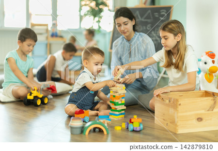 Group of children playing with various toys in kindergarten Group of children playing with various toys in kindergarten 142879810