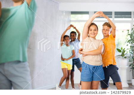 Preteen children learning to dance waltz in pairs in choreography class Preteen children learning to dance waltz in pairs in choreography class 142879929