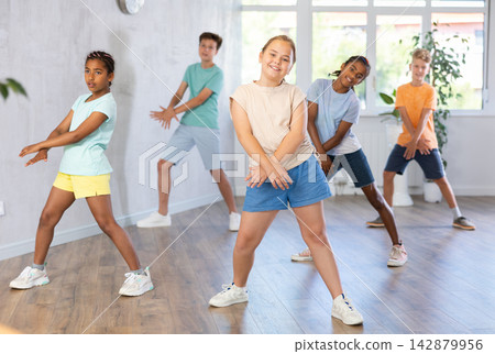 Smiling tween girl learning modern dynamic dances in choreography class 142879956